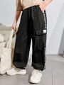 SHEIN Kids EVRYDAY Tween Boys' Casual Resort-Style Loose Woven Trousers With Letter Patch And Three-Dimensional Patch Pockets.